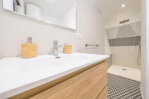 ein Badezimmer mit einem weißen Waschbecken und einer Dusche in der Unterkunft I Mezzanini - Palazzo Bonaccorsi in Milazzo