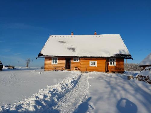 a wooden house with snow on the roof at Chalupa Jadrná 2 in Orlické Záhoří 