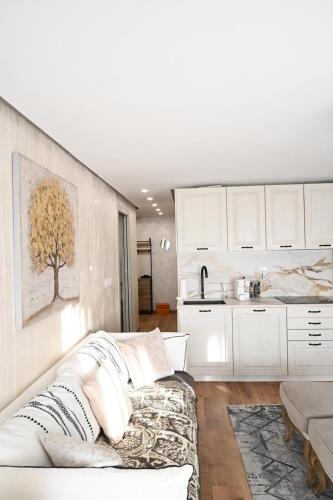 a living room with a white couch and a kitchen at Crans Montana - regent school in Lens