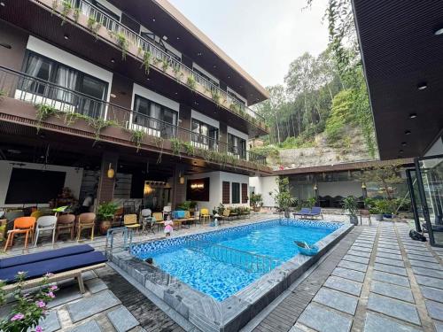 a hotel with a swimming pool in front of a building at Tran's House Cat Ba in Cat Ba