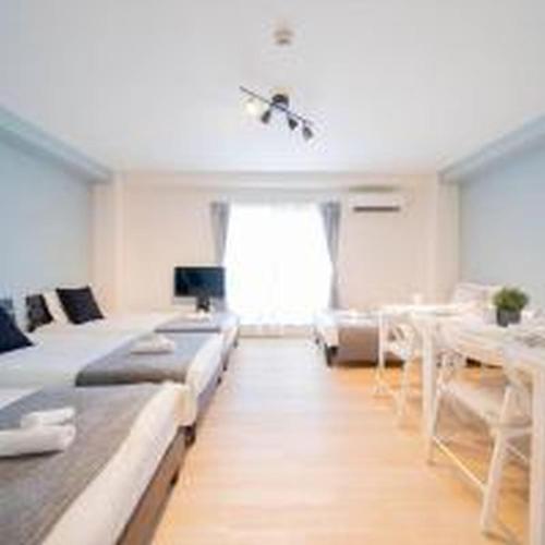 a living room with a bed and a table at Mutsumi Konohana 601 むつみ庵此花 601 in Osaka