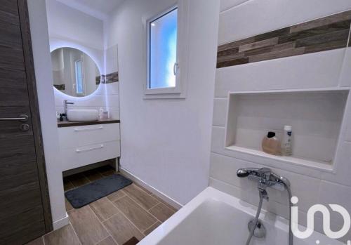 une salle de bain avec une baignoire, un lavabo et un miroir dans l'établissement Maison la Cocagne de la Sainte Baume, à Nans-les-Pins