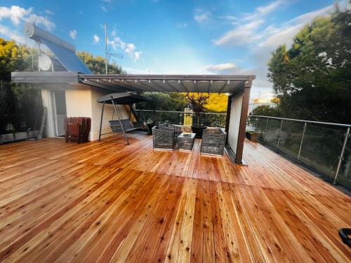 a deck with a wooden floor and a grill at Villa Shera in Mullini i Danit