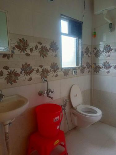 a bathroom with a toilet and a sink and a window at ILIF 2726 Beach Haven in Nāgaonkhar