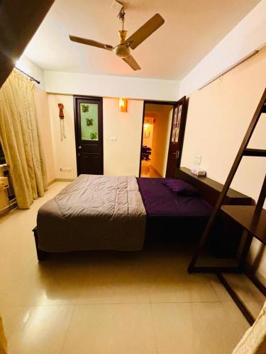 a bedroom with a bed and a ceiling fan at LUXUS INN JA - Sapphire Suite in Trivandrum