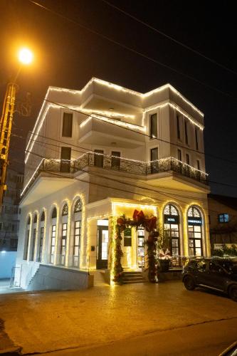 a white building with christmas lights in front of it at Cosmopolita Boutique Hotel in Timişoara