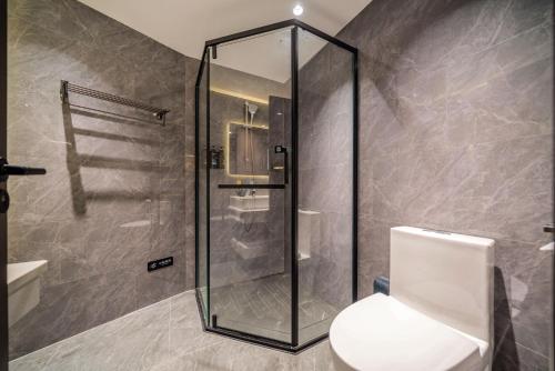 a bathroom with a glass shower and a toilet at Mei Gang Hotel in Guangzhou
