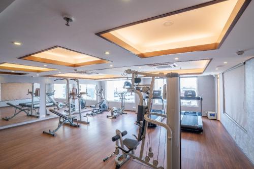 a gym with several treadmills and elliptical machines at Regenta Dehradun by Royal Orchid Hotels Limited in Dehradun