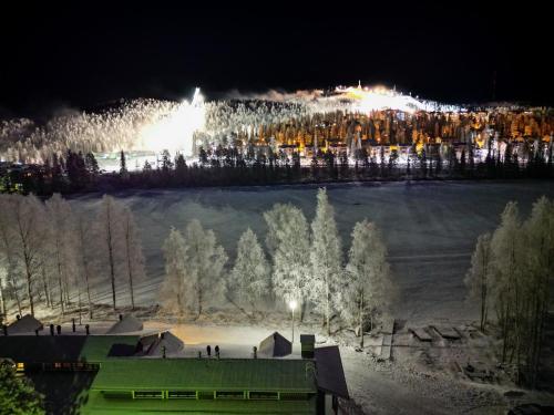 a view of a snow covered field at night at Lomakivakka - Roomy 2BD & loft by the lake, free wifi and sauna in Ruka