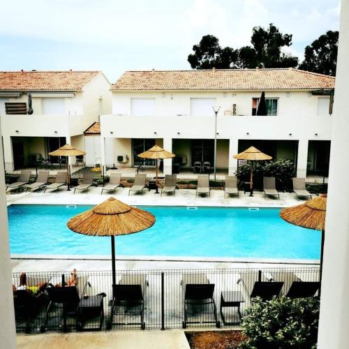 une grande piscine avec chaises et parasols dans l'établissement marina di bravone - corse - linguizzetta, à Linguizzetta