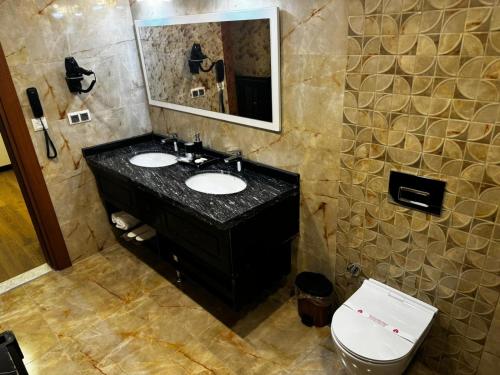 un bagno con due lavandini, uno specchio e un water di Pacis Antakya a Hatay