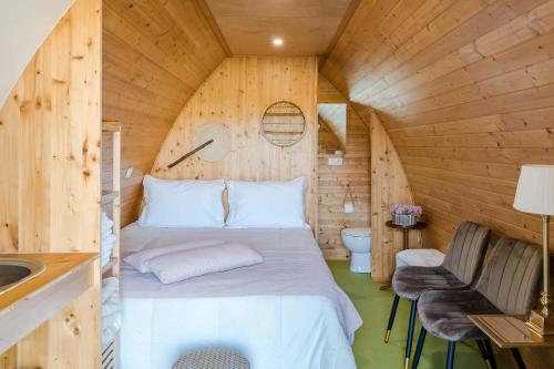 a bedroom in a log cabin with a bed and a sink at Villam Vale da Estrela in Guimarães