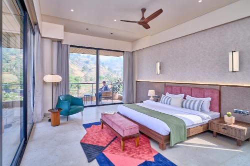 a bedroom with a large bed and a balcony at SaffronStays Eldora by the Lake in Matheran