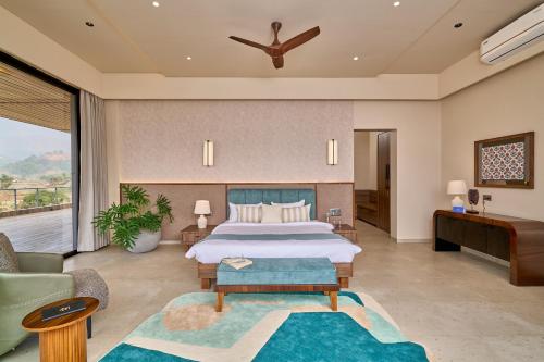 a bedroom with a large bed and a couch at SaffronStays Eldora by the Lake in Matheran