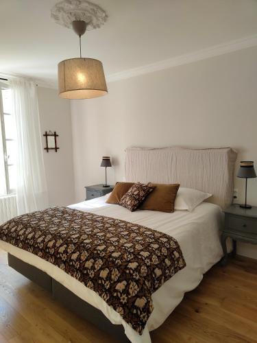 une chambre avec un grand lit et deux tables de nuit dans l'établissement La Maison de Bujan, à Gauriac