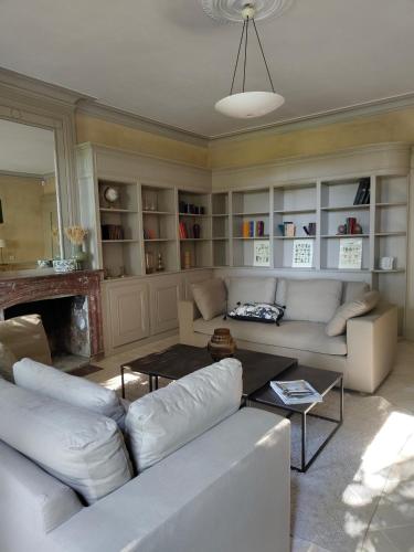 Elle comprend un salon doté d'un mobilier blanc et d'une cheminée. dans l'établissement La Maison de Bujan, à Gauriac