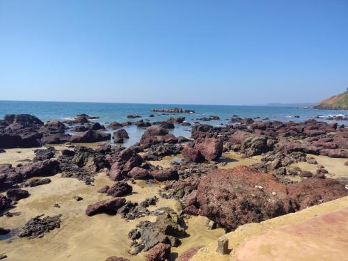 a beach filled with rocks and the ocean at Shree Sai Beach Stay in Arambol