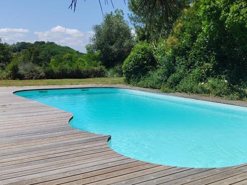 - une piscine bleue sur une terrasse en bois dans l'établissement La Maison de Bujan, à Gauriac