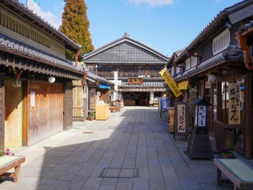 an empty street in an asian town with buildings at 絶景海風癒し庵 新八屋 in Toba