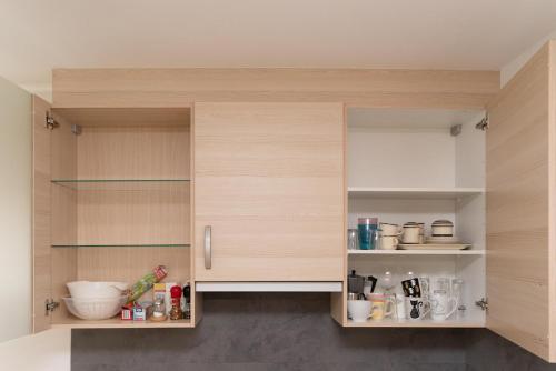 a kitchen with wooden cabinets with utensils at Cozy Garconniere near Innsbruck in Völs