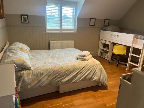 a small bedroom with a bed and a desk at Elmcroft, Large House with Shepherds Hut in Gillingham