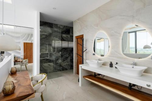 ein Badezimmer mit zwei Waschbecken und einem Spiegel in der Unterkunft Villa Kelapa Koh Samui in Koh Samui 