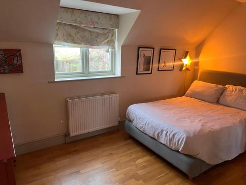 a bedroom with a bed and a window at Elmcroft, Large House with Shepherds Hut in Gillingham