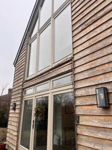 a house with glass windows on the side of it at Elmcroft, Large House with Shepherds Hut in Gillingham