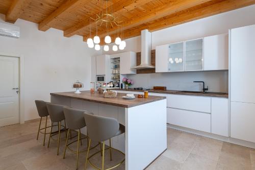a kitchen with white cabinets and a wooden ceiling at Villa Ljubica in Suđurađ