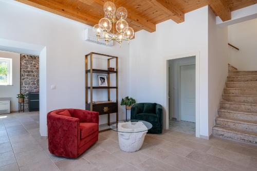 a living room with a red chair and a chandelier at Villa Ljubica in Suđurađ