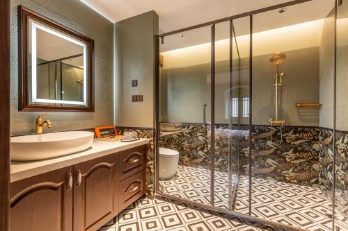 a bathroom with a sink and a shower at Beijing Xiaofengxian Former Residence Hotel Tiananmen Square Qianmen Store in Beijing