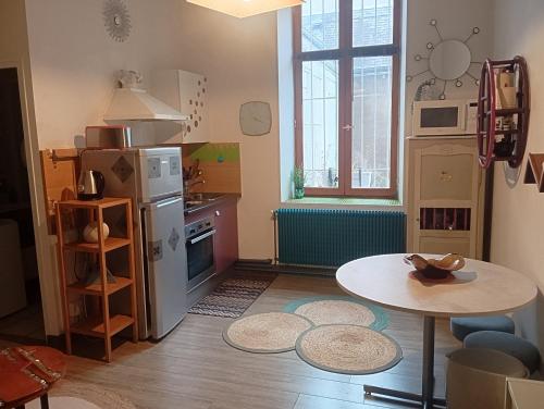 une petite cuisine avec une table et une petite table dans l'établissement Charmant meublé deux chambres, à Châteauroux