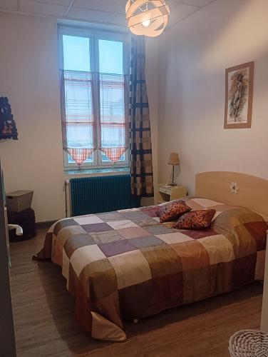 une chambre avec un lit et une grande fenêtre dans l'établissement Charmant meublé deux chambres, à Châteauroux