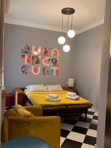 a bedroom with a yellow bed and a couch at Pop's Apartments in Belgrade