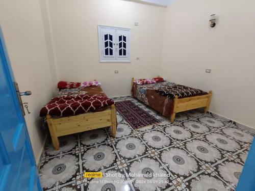 a small room with two beds and a window at Amoun أمون in Siwa
