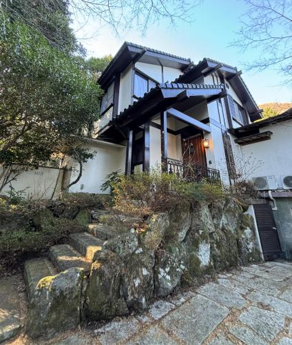 a house with a stone path in front of it at 箱根温泉ヴィラ 源泉かけ流し bbq付き グループ宿泊に最適 in Hakone
