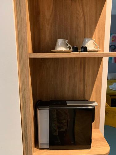 a small microwave in a wooden shelf with at Pop's Apartments in Belgrade
