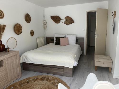 une chambre avec un lit avec des draps blancs dans l'établissement Le Cafranc - Appt en pleine nature, à Le Tholy