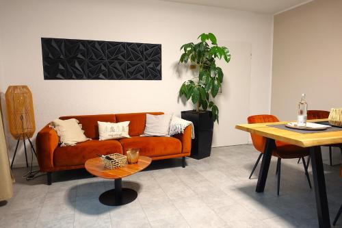 a living room with a couch and a table at Getaway Apartment - Balkon - Küche - Ruhe - Wäsche - S-Bahn - 60 qm in Duisburg