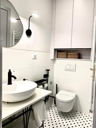 a white bathroom with a sink and a toilet at Pop's Apartments in Belgrade