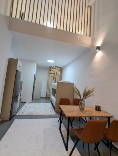 a living room with a table and chairs and a staircase at Luxury Loft Μοντέρνο διαμέρισμα 2 επιπέδων in Giannitsa