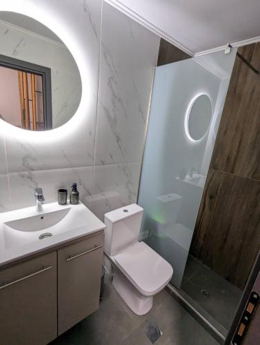 a bathroom with a toilet and a sink and a mirror at Luxury Loft Μοντέρνο διαμέρισμα 2 επιπέδων in Giannitsa