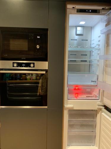 a kitchen with an open refrigerator with a microwave at Pop's Apartments in Belgrade