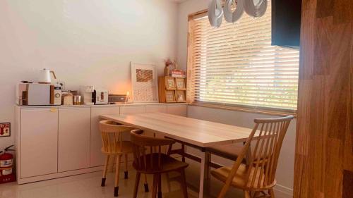 a kitchen with a wooden table and chairs at Im Youngchon in Gangneung