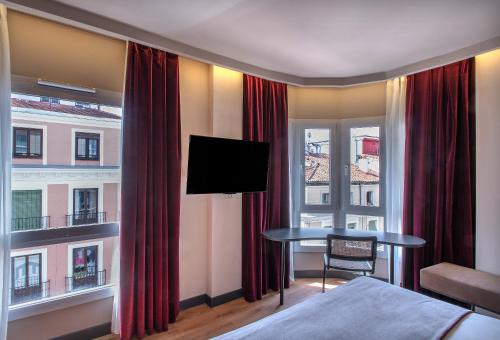 a hotel room with a bed and a table with a television at Ibis Styles Madrid Centro Maravillas in Madrid
