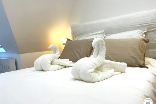 deux animaux farcis sont assis sur un lit dans l'établissement Le Petit Palais - 50m Plage - Vue mer et campagne, à Tourgéville