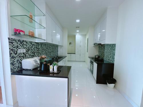 a kitchen with white cabinets and a black counter top at Infinity 28 Hotel and Residence in Phnom Penh