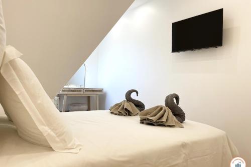 2 cygnes de serviettes assises au-dessus d'un lit dans l'établissement Le Grand Palais - 50m Plage - Vue mer - Tennis, à Tourgéville