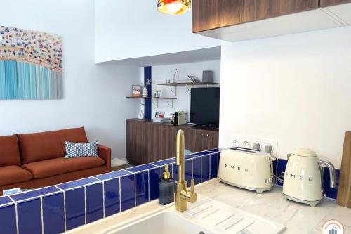 Il dispose d'une cuisine avec un évier et d'un salon avec un canapé. dans l'établissement Temps des Cerises - Terrasse - Plage - Marina, à Deauville