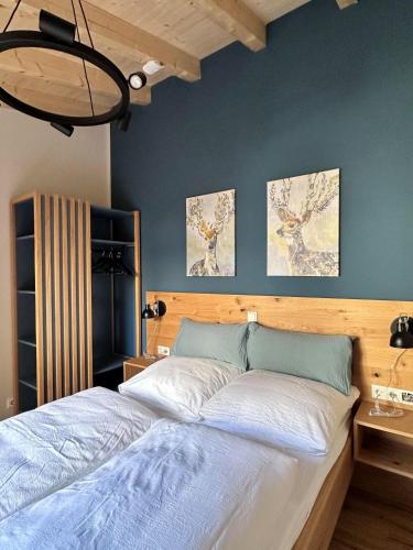 a bed in a bedroom with three paintings on the wall at Ferienhaus rausZeit in Dernau
